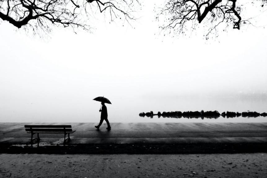 Imagen ornamental, un hombre caminando bajo la lluvia con paraguas, por Cristophe Dutour, en Unsplash, CC0