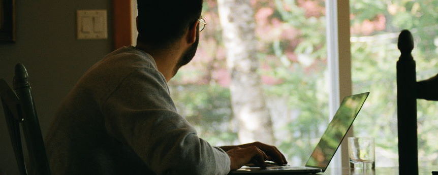 Imagen ornamental. Un hombre trabajando con un ordenador delante de una ventana